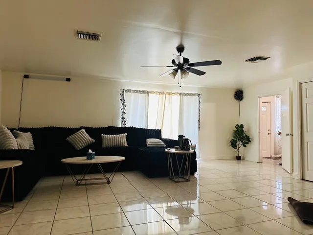 a living room with furniture and a ceiling fan