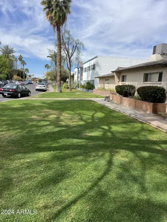 a front view of a house with a garden and trees