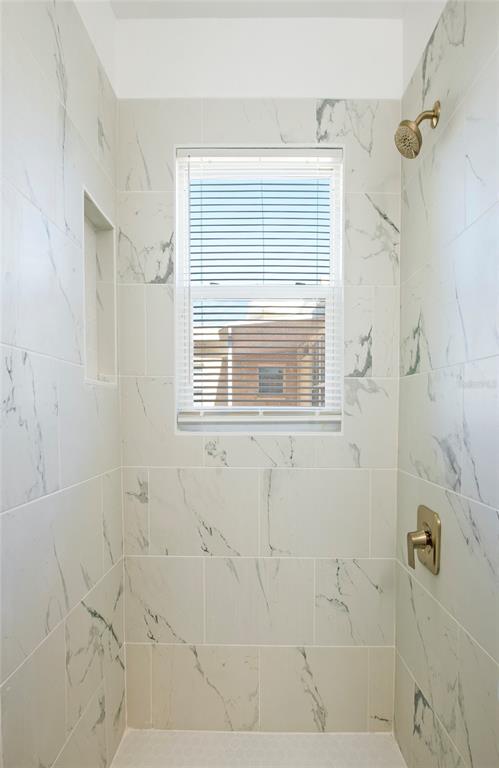 717 East Gulf Boulevard Indian Rocks Beach, FL 33785 - Photo 14 of 65 a bathroom with a window and shower