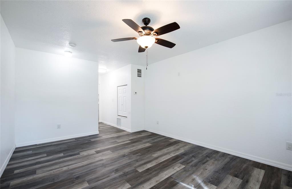 717 East Gulf Boulevard Indian Rocks Beach, FL 33785 - Photo 31 of 65 an empty room with wooden floor and ceiling fan