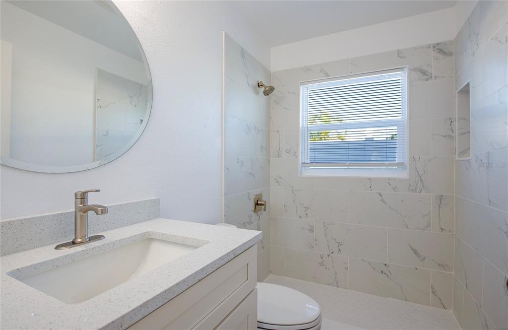 717 East Gulf Boulevard Indian Rocks Beach, FL 33785 - Photo 49 of 65 a bathroom with a sink toilet and shower