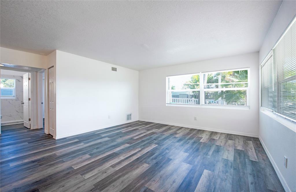 717 East Gulf Boulevard Indian Rocks Beach, FL 33785 - Photo 54 of 65 an empty room with wooden floor and windows