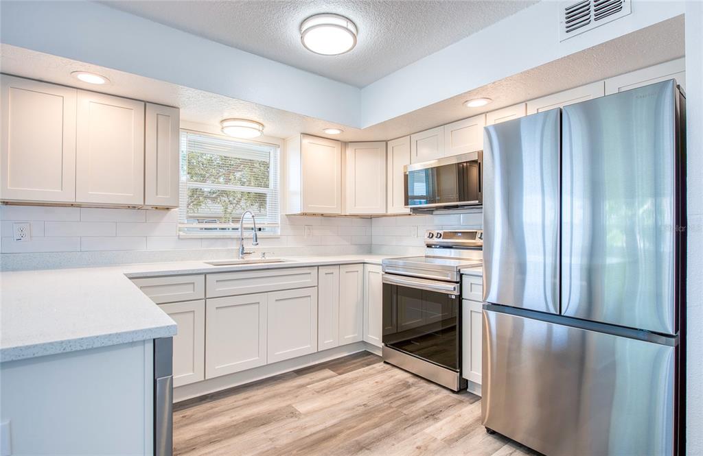 717 East Gulf Boulevard Indian Rocks Beach, FL 33785 - Photo 60 of 65 a kitchen with a refrigerator sink and microwave