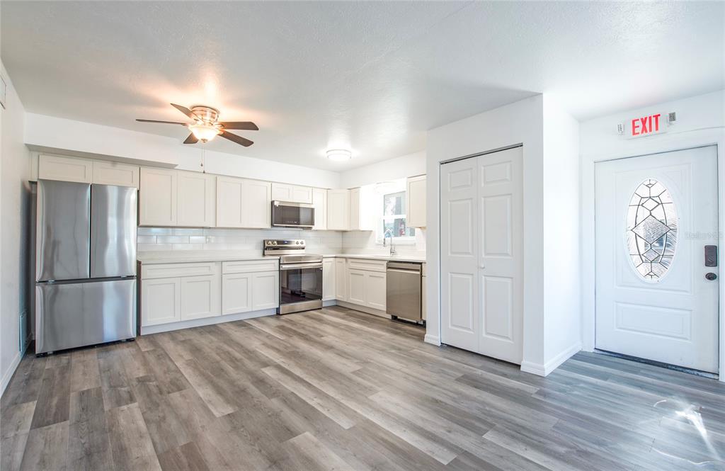 717 East Gulf Boulevard Indian Rocks Beach, FL 33785 - Photo 7 of 65 a kitchen with white cabinets and white appliances