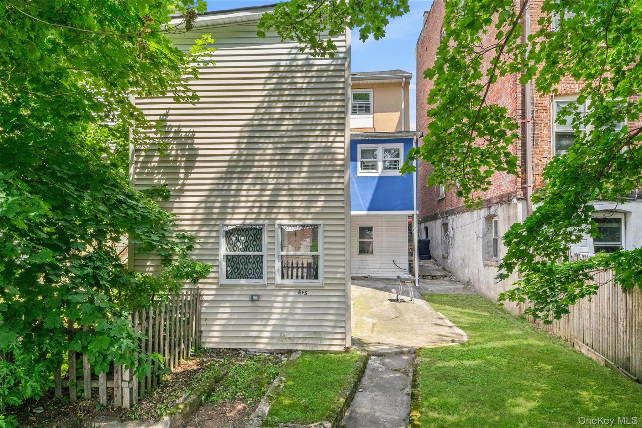 931 Diven Street Peekskill, NY 10566 - Photo 22 of 29 Rear exterior on sloped grassy landscape