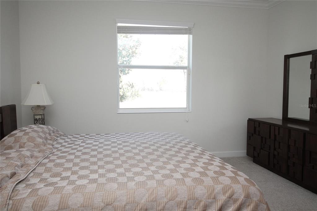 3752 Quaint Lane Clermont, FL 34711 - Photo 16 of 49 a bedroom with a bed and a flat tv screen on a dresser