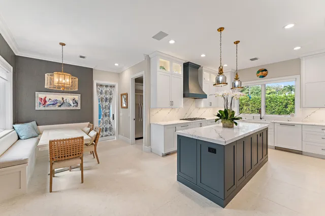 a kitchen with kitchen island granite countertop a sink counter top space appliances and a window