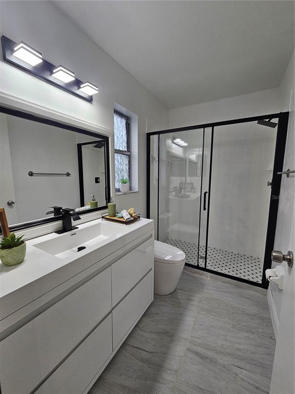 1025 Clovercrest Road Orlando, FL 32811 - Photo 16 of 27 a bathroom with a double vanity sink and mirror with toilet