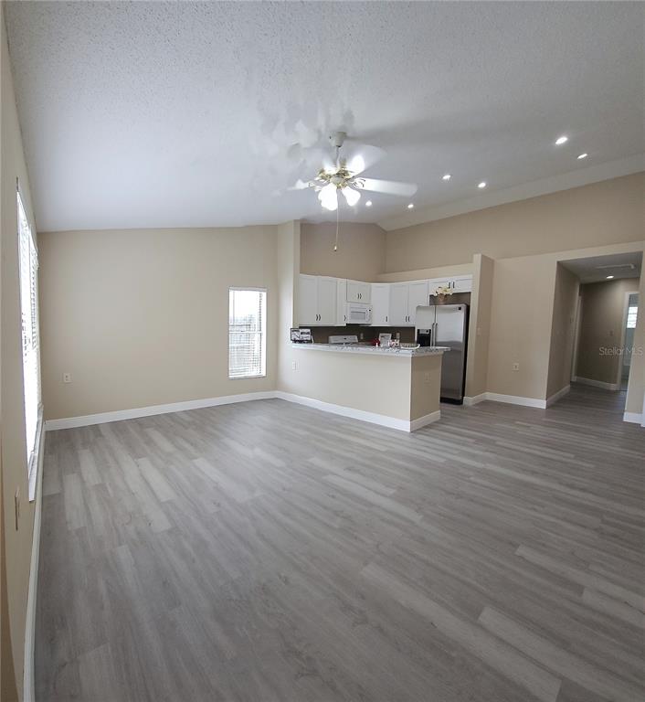 1025 Clovercrest Road Orlando, FL 32811 - Photo 5 of 27 a view of empty room with wooden floor and kitchen view