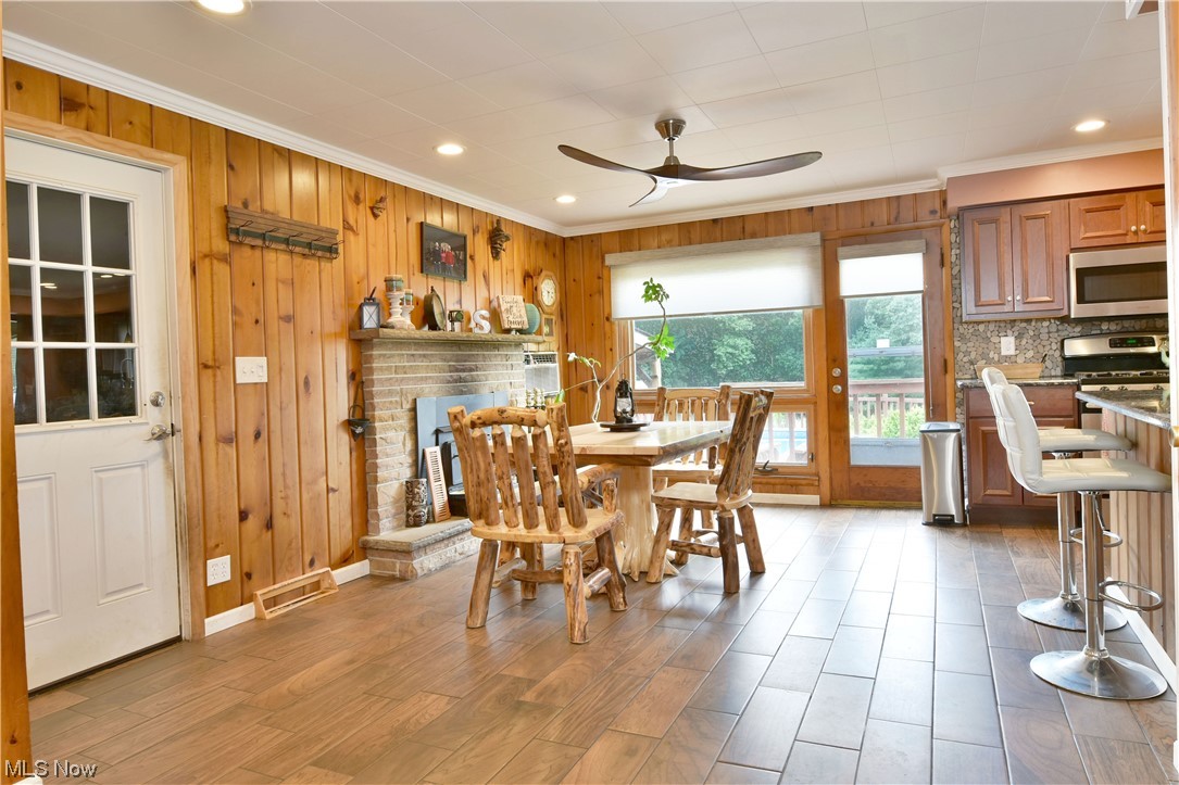 1711 Salt Springs Road Mineral Ridge, OH 44440 - Photo 9 of 35 Ceramic wood look floored dining room featuring wood walls, ornamental molding, and ceiling fan