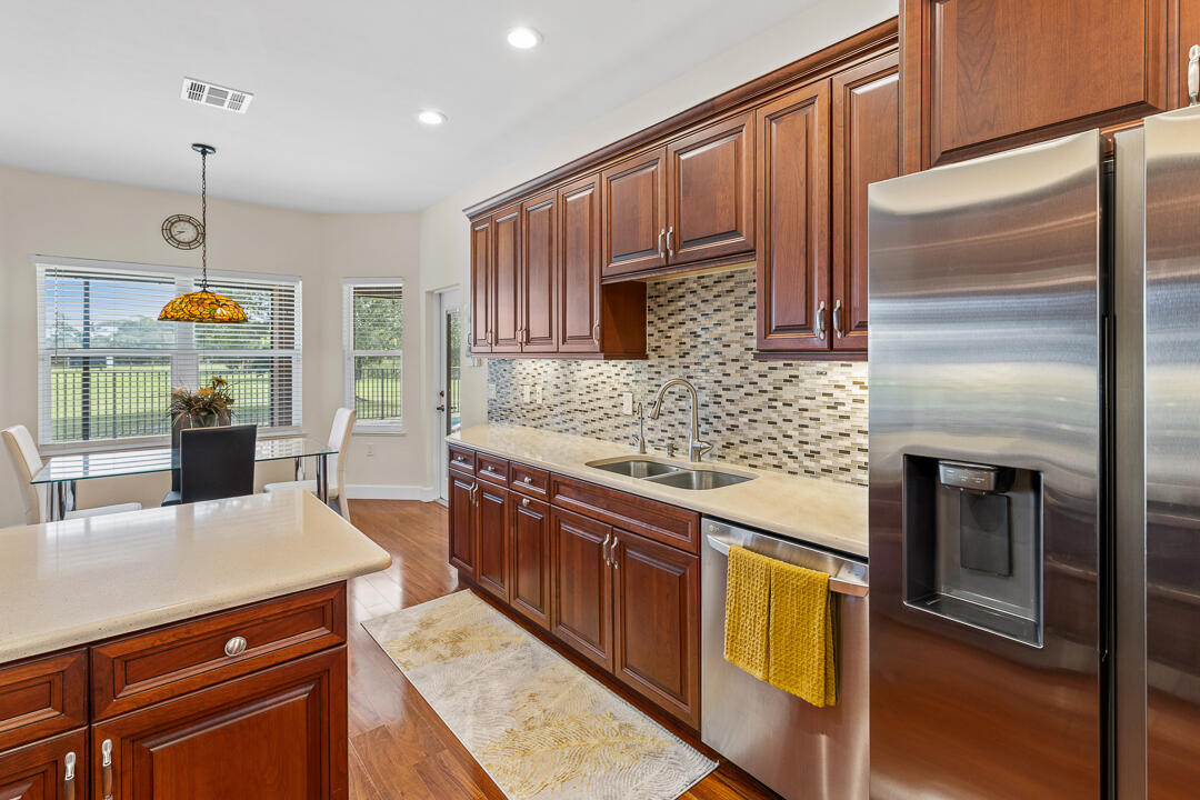 2774 Gentile Road Fort Pierce, FL 34945 - Photo 20 of 70 a kitchen with stainless steel appliances granite countertop a sink a stove and a refrigerator