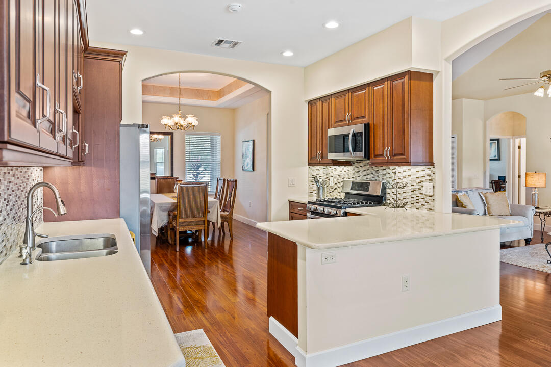 2774 Gentile Road Fort Pierce, FL 34945 - Photo 22 of 70 a kitchen with stainless steel appliances a stove a sink a oven a dining table and chairs