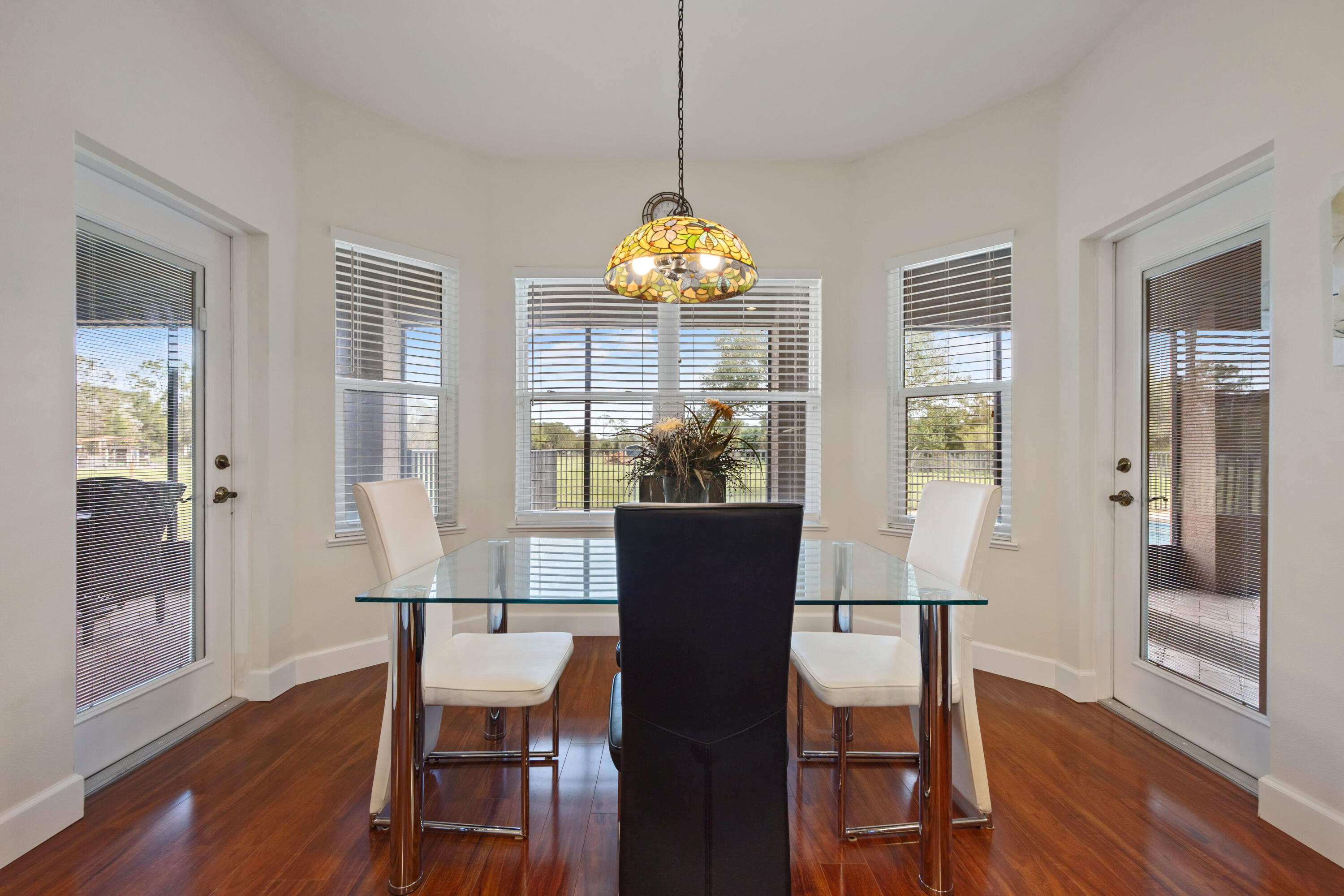 2774 Gentile Road Fort Pierce, FL 34945 - Photo 24 of 70 a dining room with wooden floor a glass table and chairs