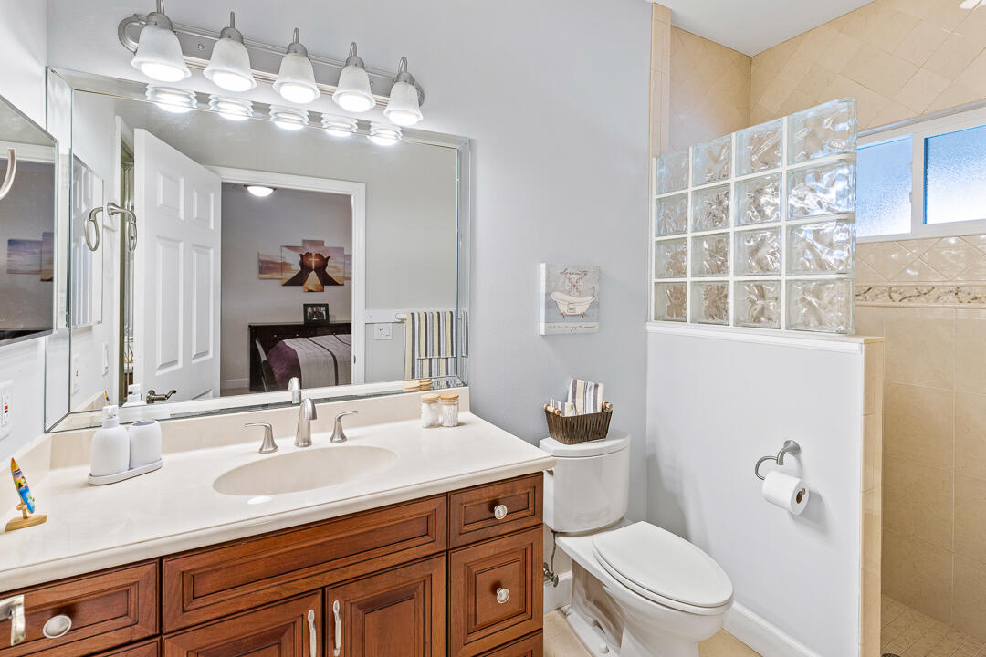 2774 Gentile Road Fort Pierce, FL 34945 - Photo 32 of 70 a bathroom with a granite countertop toilet sink and mirror