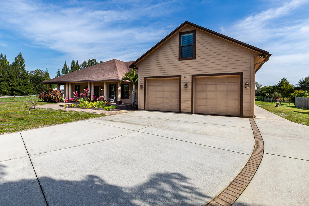 2774 Gentile Road Fort Pierce, FL 34945 - Photo 60 of 70 a front view of a house with a yard and potted plants