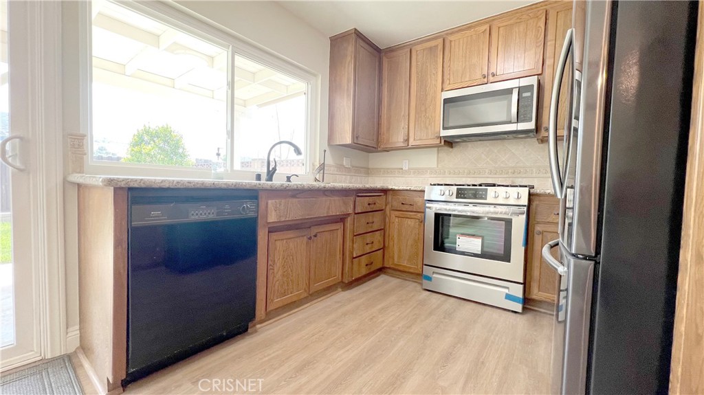5708 Damon Street Simi Valley, CA 93063 - Photo 9 of 23 a kitchen with stainless steel appliances a stove sink and microwave