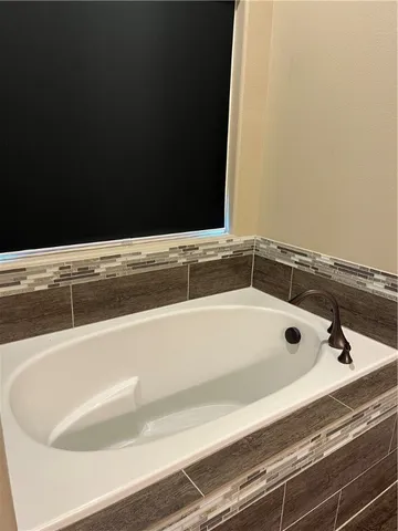 a bathroom with a bathtub and mirror