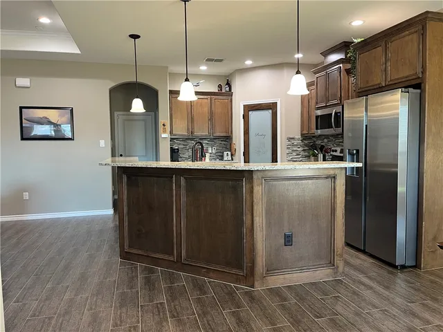 a kitchen with stainless steel appliances granite countertop a refrigerator a sink and a stove