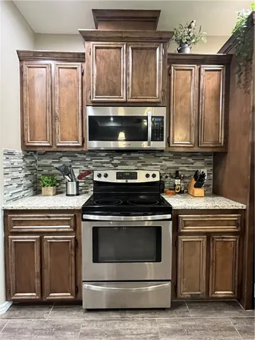 a kitchen with granite countertop a stove and a microwave