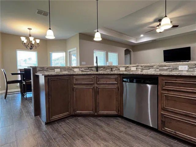 a kitchen with kitchen island granite countertop a sink cabinets and stainless steel appliances