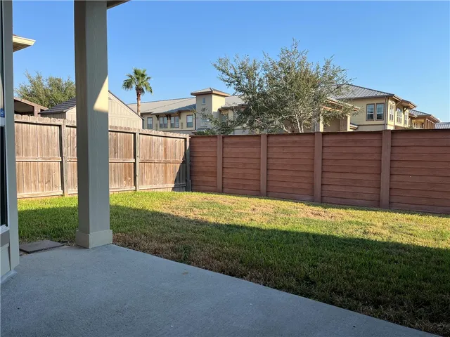 a view of a backyard with wooden fence