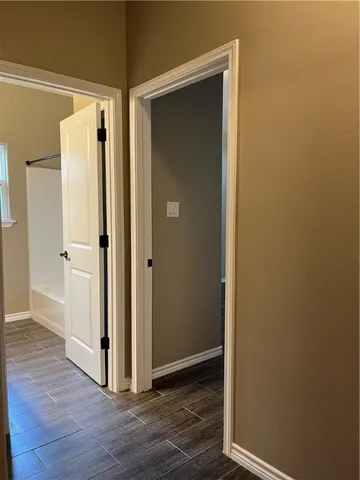 a view of a hallway with wooden floor