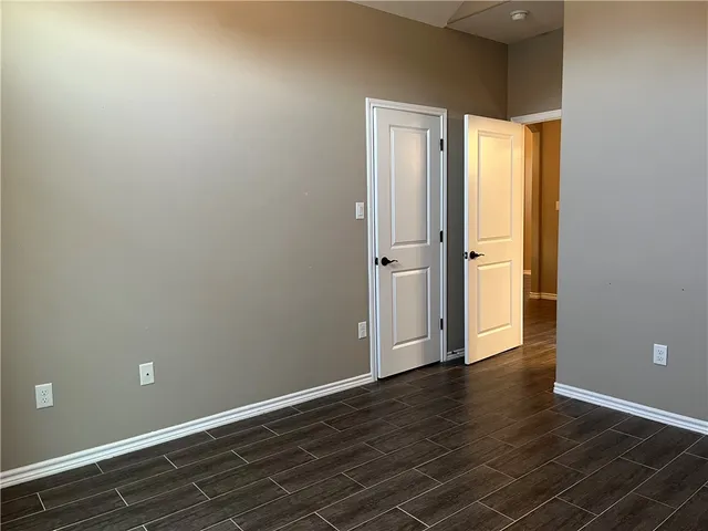 an empty room with wooden floor and sliding door