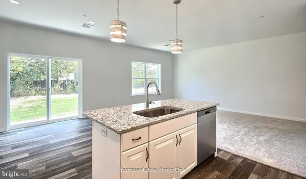 a kitchen with a sink and wooden floor