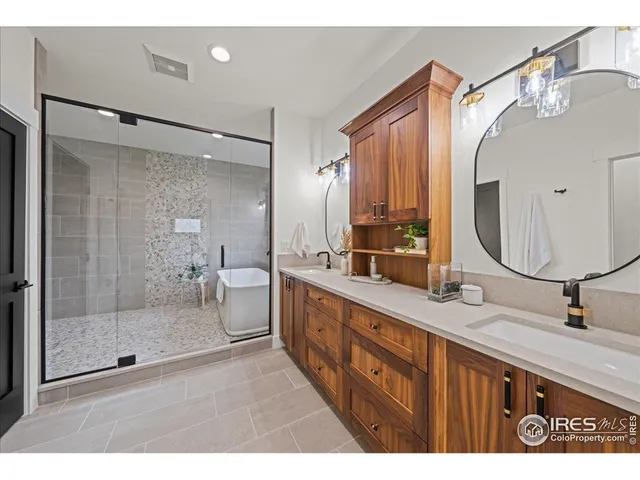 a bathroom with a double vanity sink mirror and shower