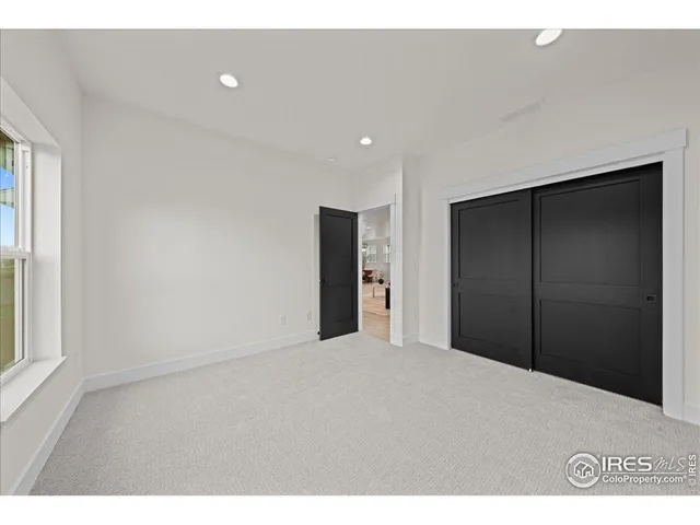 a view of an empty room with window and bathroom