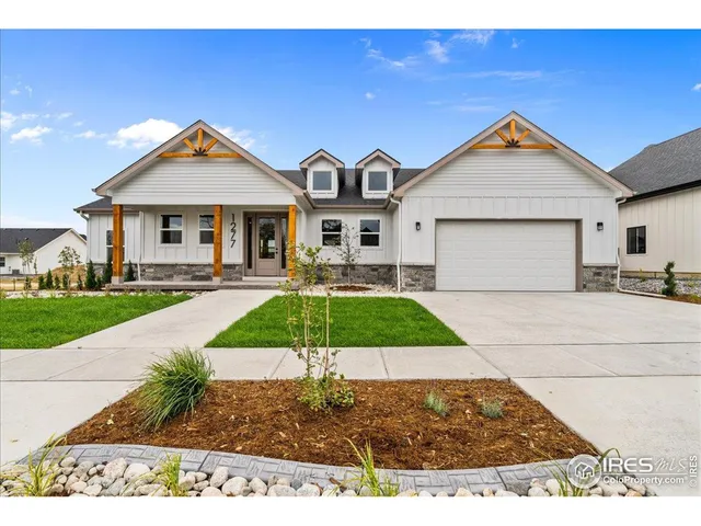a view of a white house with a small yard and plants