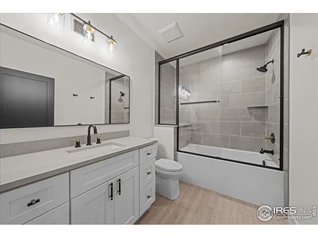 a bathroom with a shower sink vanity mirror and toilet