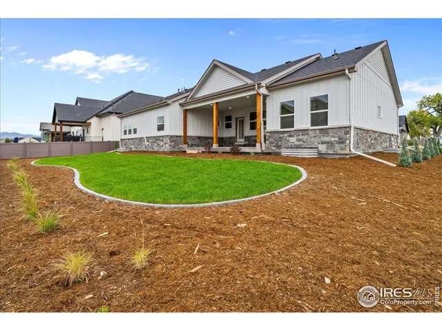 a view of a white house with a big yard and potted plants