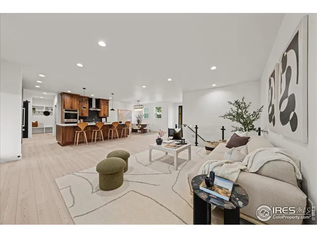 a living room with furniture a table and kitchen view