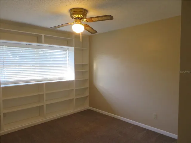 a view of room with window and ceiling fan