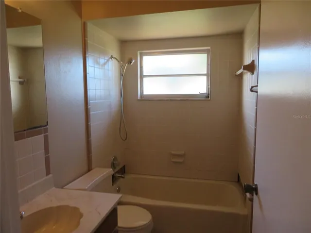 a bathroom with a bathtub toilet and window