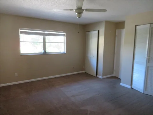 an empty room with windows and closet