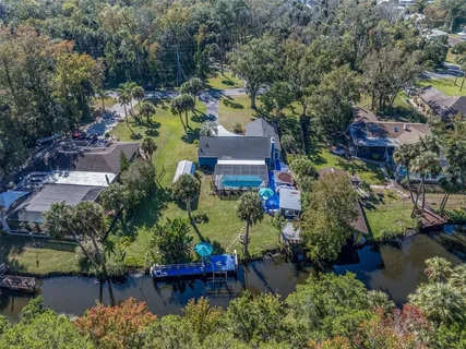 an aerial view of a house with a garden and lake view