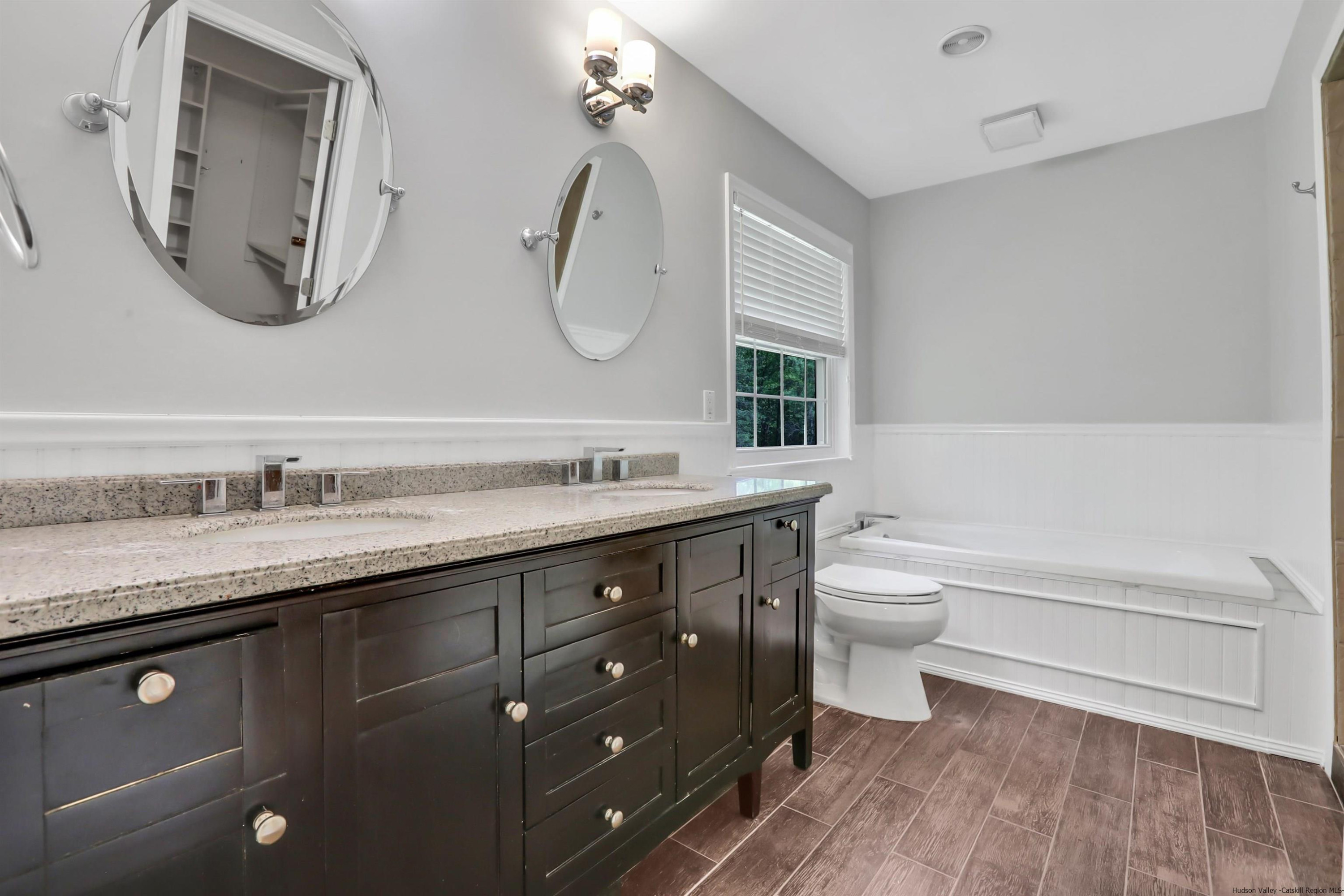 1 High Ridge Road, Unit KLEINKILL DR New Paltz, NY 12561 - Photo 21 of 30 a bathroom with a granite countertop toilet a double vanity sink and a mirror