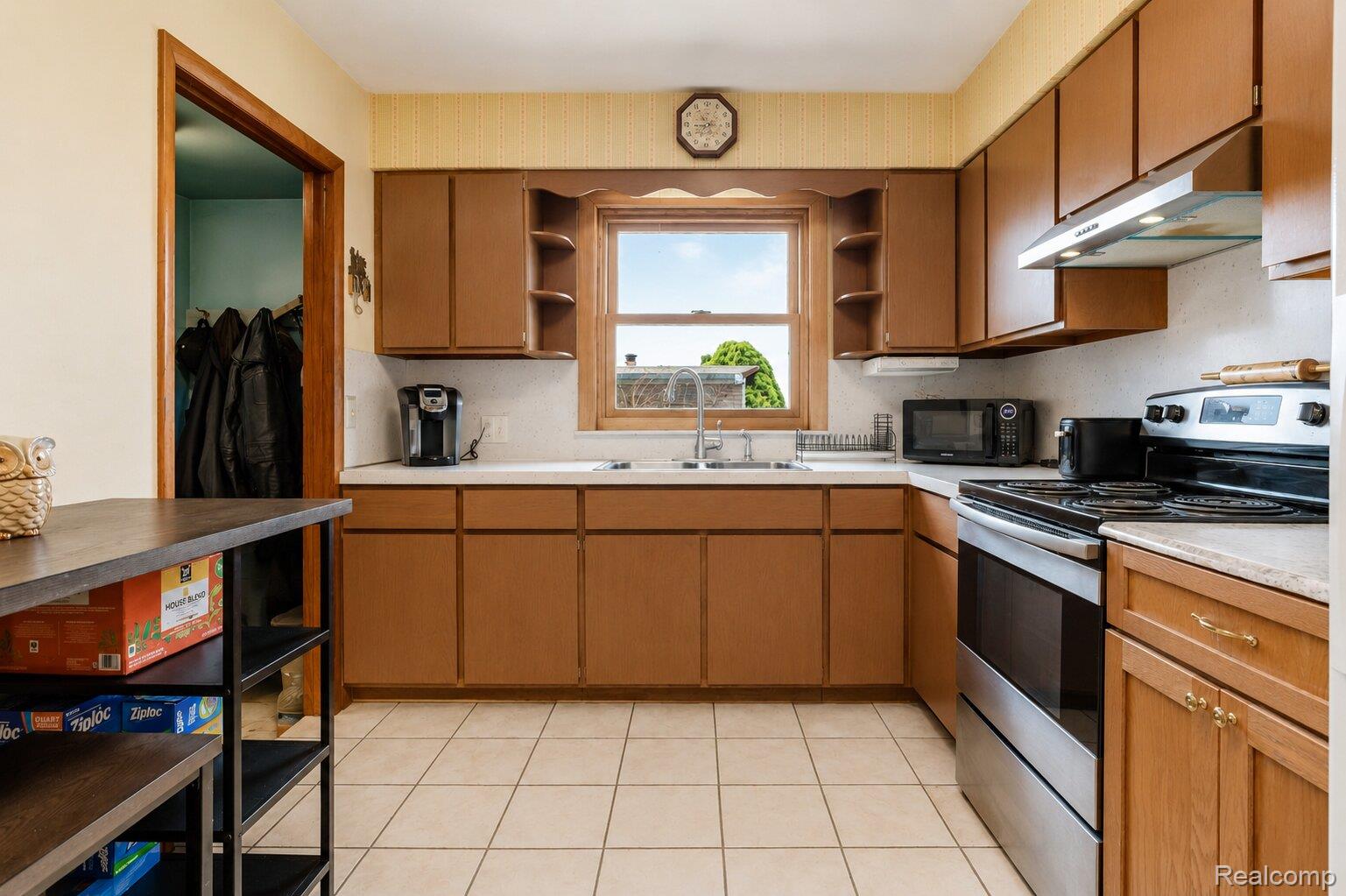 6373 Norman Road Jeddo, MI 48032 - Photo 7 of 32 Kitchen featuring stainless steel range with electric stovetop, wood finish cabinets, open shelves, light countertops, and black microwave