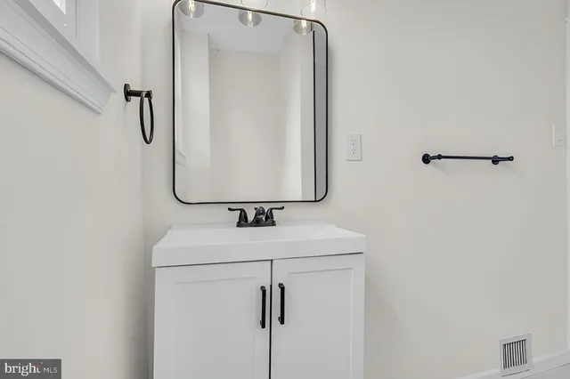 a bathroom with a sink vanity and mirror