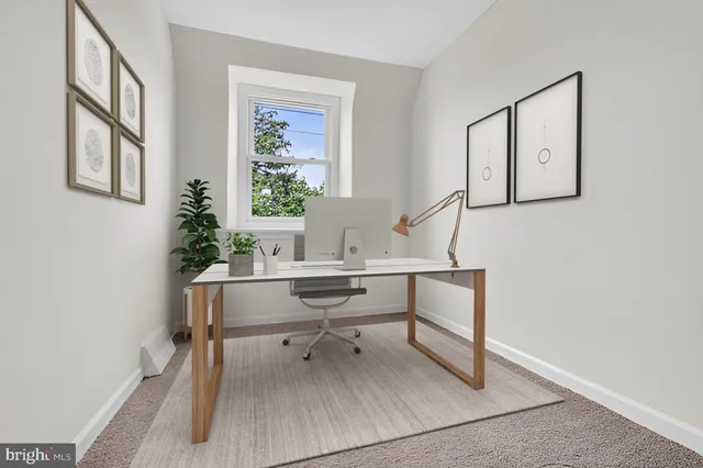 a view of a workspace with furniture and a window