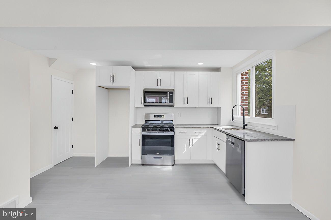 1300 East Sharpnack Street Philadelphia, PA 19150 - Photo 8 of 31 a kitchen with granite countertop white cabinets and stainless steel appliances