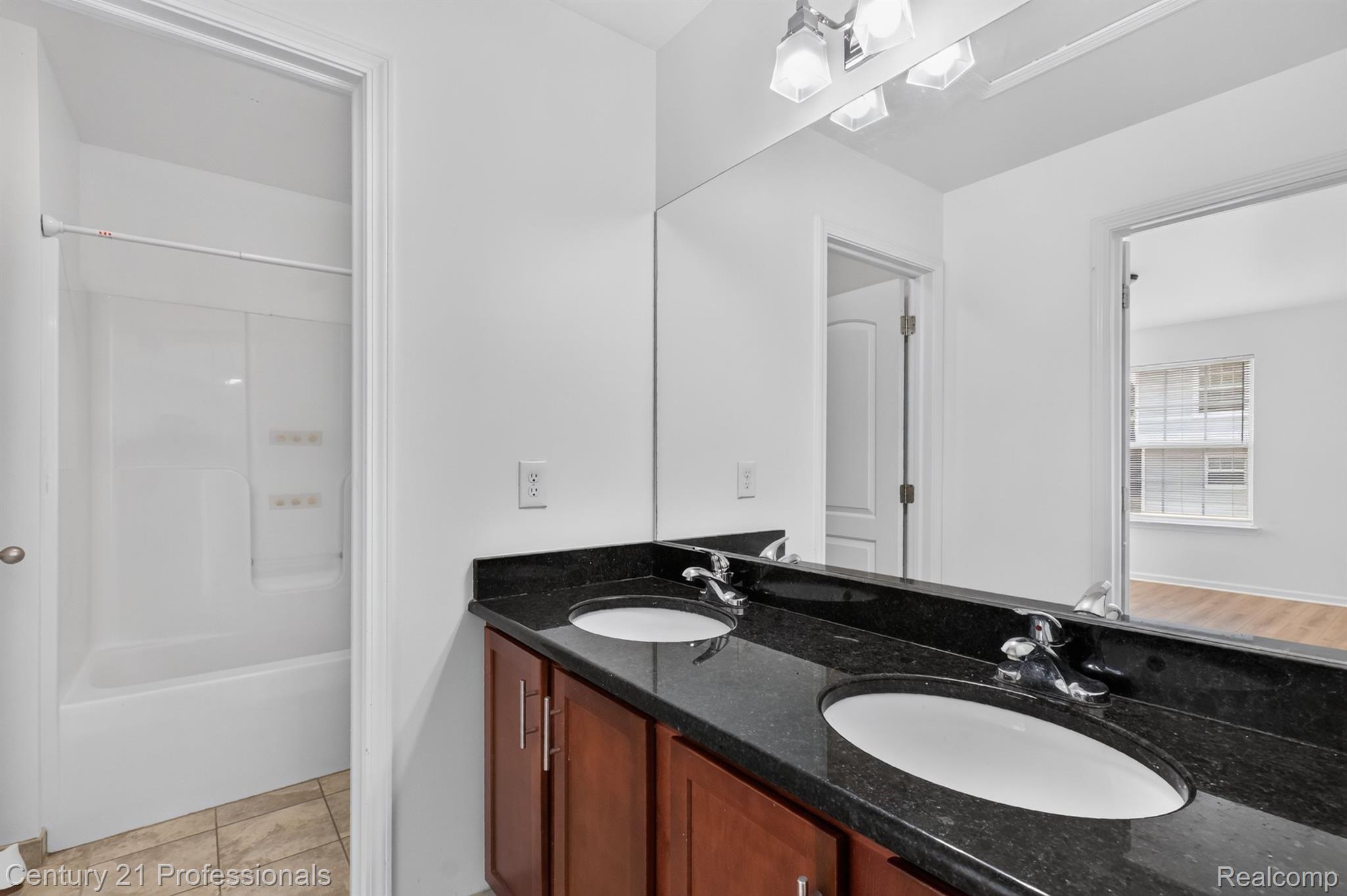 2042 Decker Road Walled Lake, MI 48390 - Photo 35 of 48 2 ND floor bath shared by 3 additional bedrooms. Dual vanity with dark countertop, undermount sinks, and wood-finish cabinetry