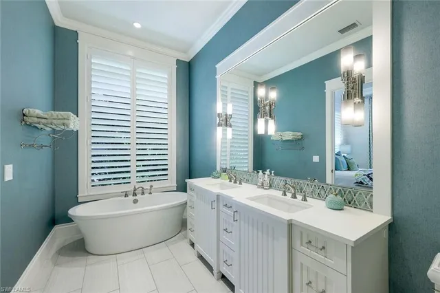 a bathroom with a double vanity sink a large mirror and a bathtub