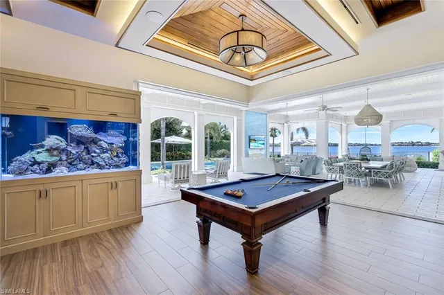 a living room with furniture pool table and a large window