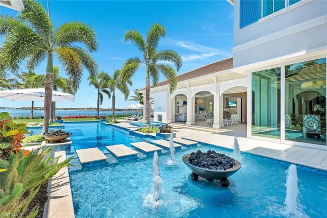 a view of a white house with swimming pool in front of it