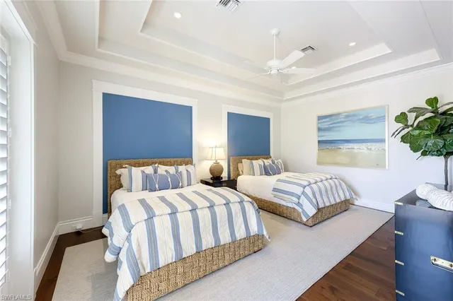 a bedroom with two beds and potted plant