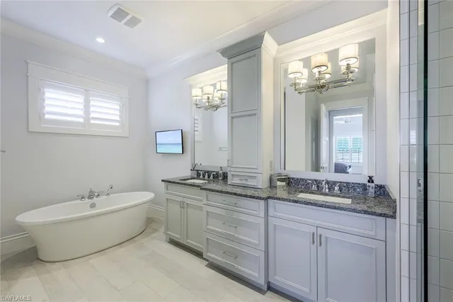 a bathroom with a double vanity sink mirror and bathtub