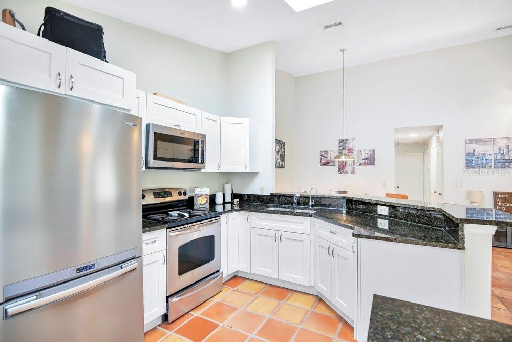 1500 Rivers Edge Drive Orlando, FL 32825 - Photo 10 of 33 a kitchen with granite countertop a sink a stove and refrigerator